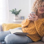 Women in sweater looking comfortable because she knows the best thermostat settings for winter