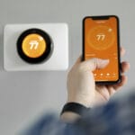 A man in Charlottesville Virginia uses their phone to program their thermostat