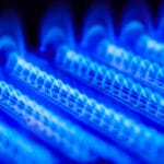 Propane flame inside of a gas boiler lights up in blue with a purple background